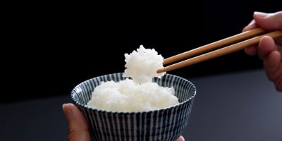 Chopsticks picking up white rice from a bowl