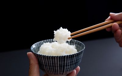 Chopsticks picking up white rice from a bowl